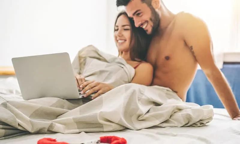 Um casal na cama lendo contos eróticos